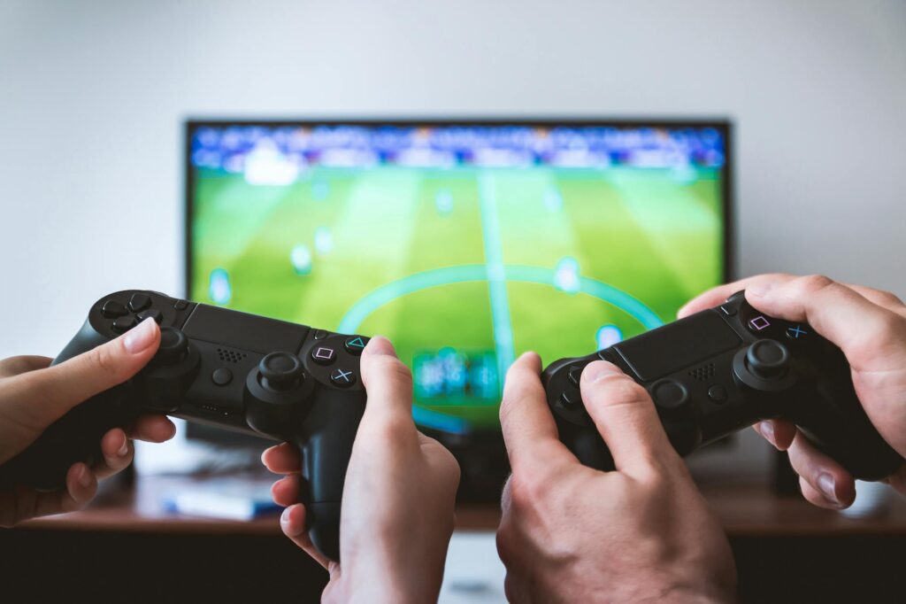 Two People holding Black Gaming Consoles, uticaj video igara
